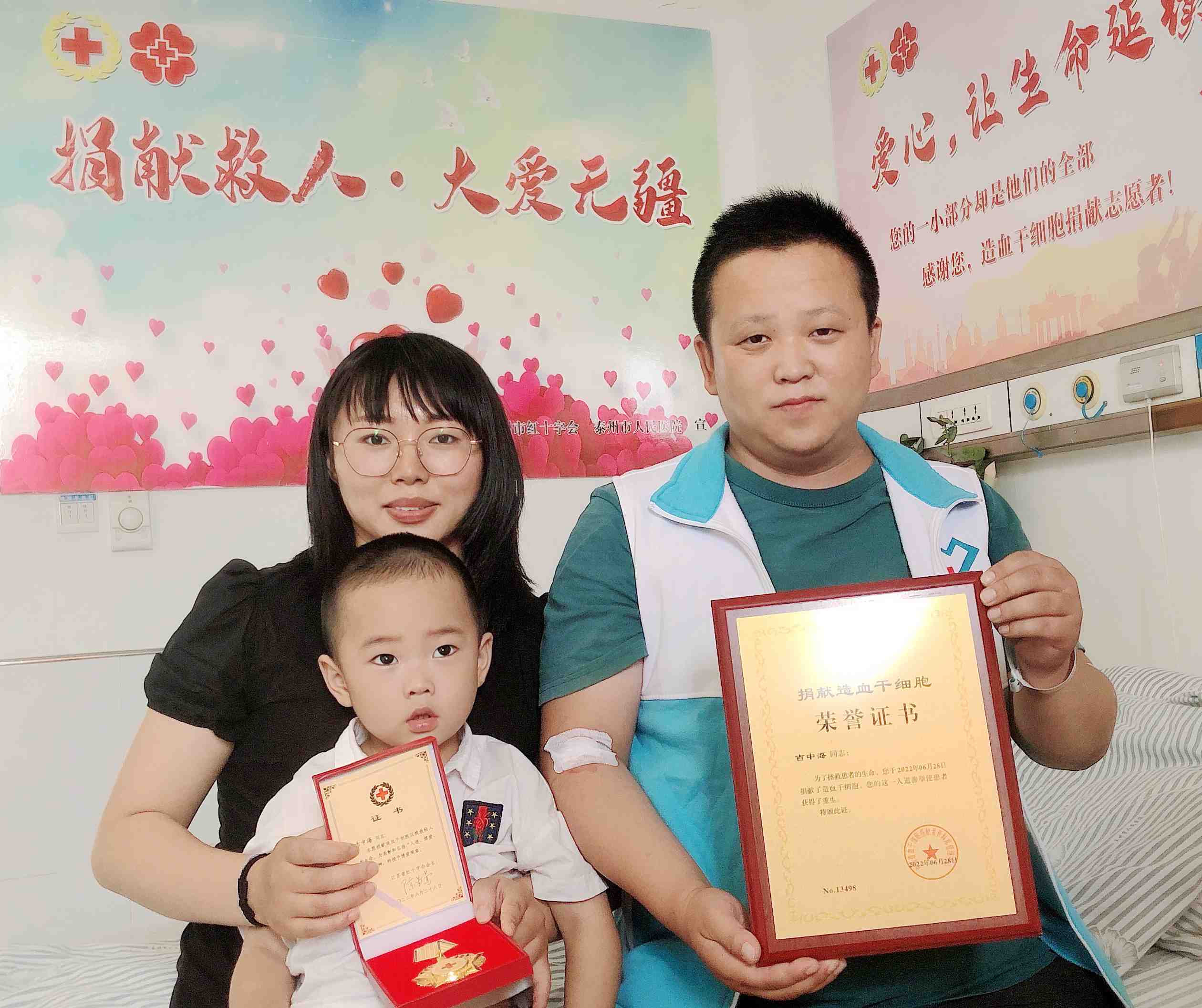 吉中海一家三口幸福展示造血干细胞捐献荣誉证书和奖章_副本.jpg
